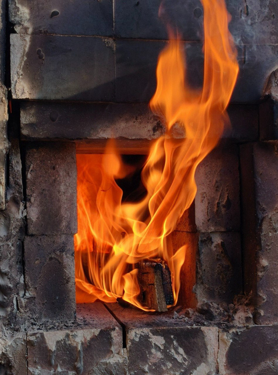 Flames rising through the wood-fired kiln firebox.