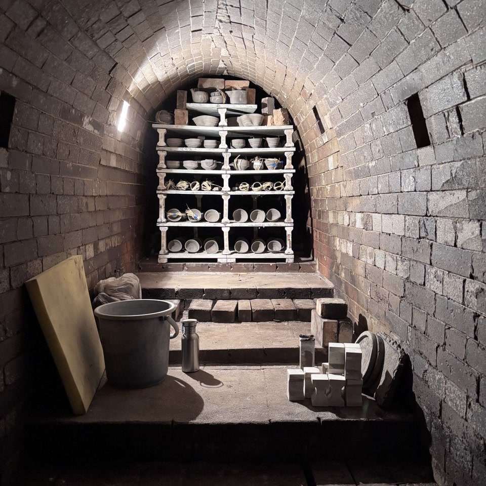 The loaded interior chamber of an anagama kiln, with ceramic pieces placed on shelves before firing.