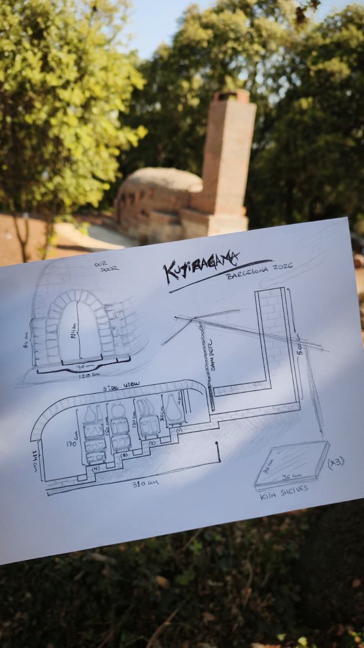 A hand-drawn plan of Kujiragama held in front of the anagama and its brick chimney at Can Brull.
