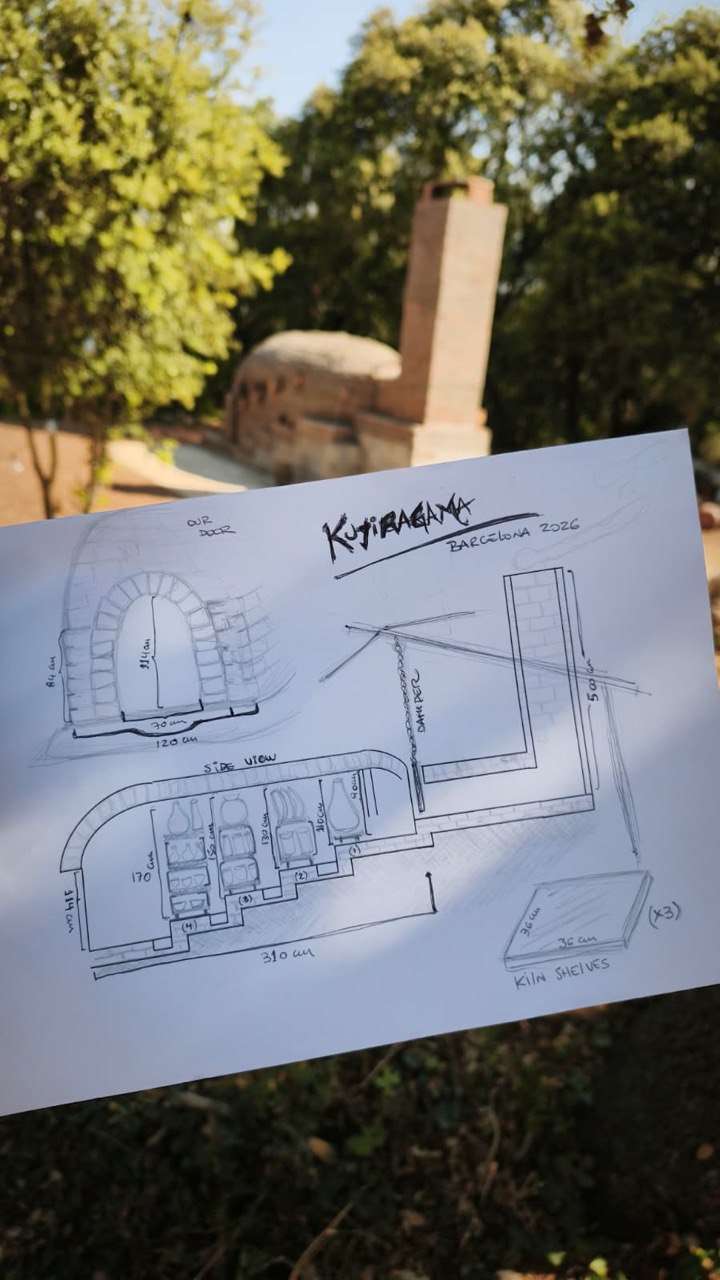 A hand-drawn plan of Kujiragama held in front of the anagama and its brick chimney at Can Brull.