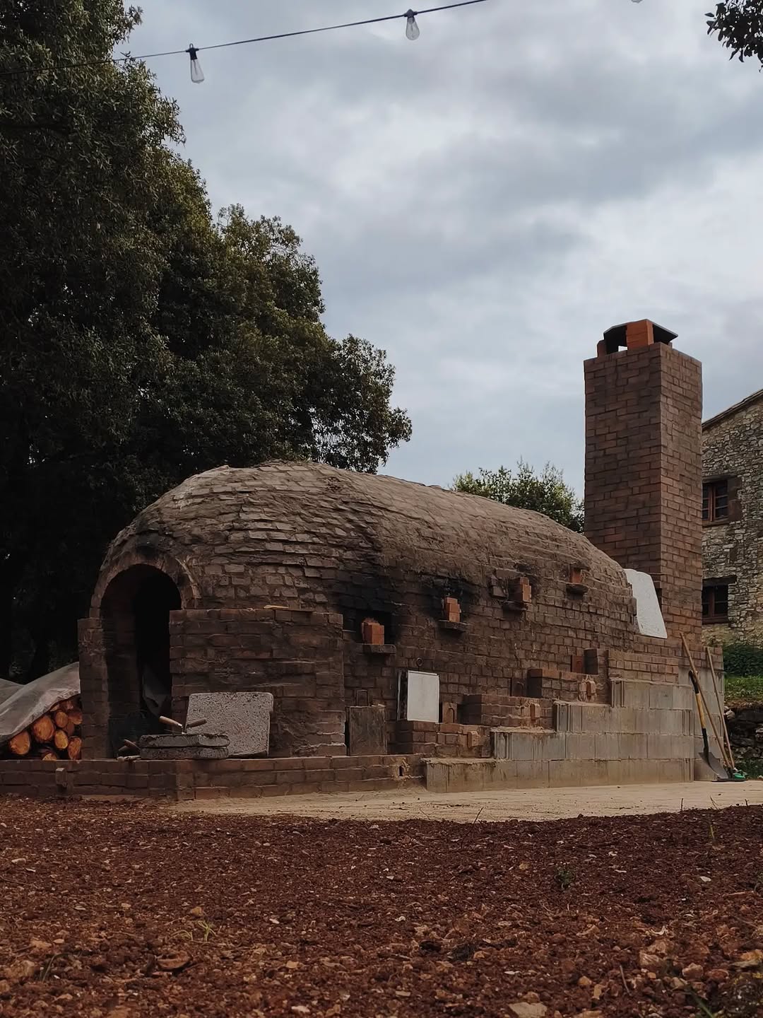 The Kujiragama anagama kiln and its brick chimney in front of the Can Brull masia.