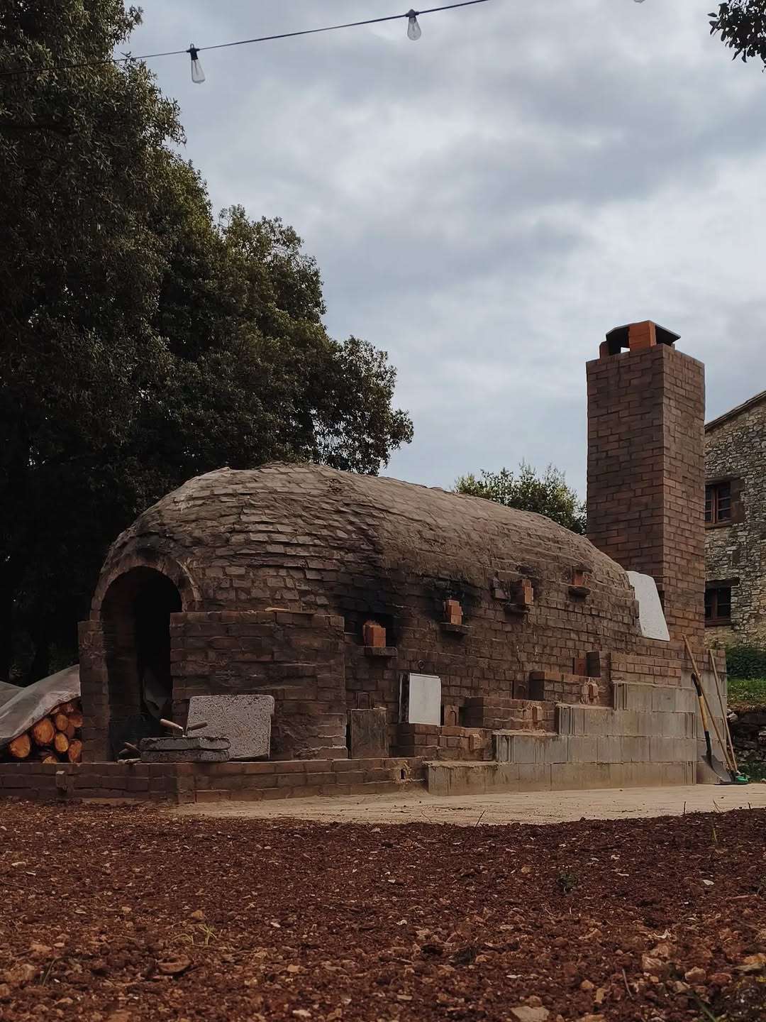 El horno anagama Kujiragama y su chimenea de ladrillo frente a la masía de Can Brull.